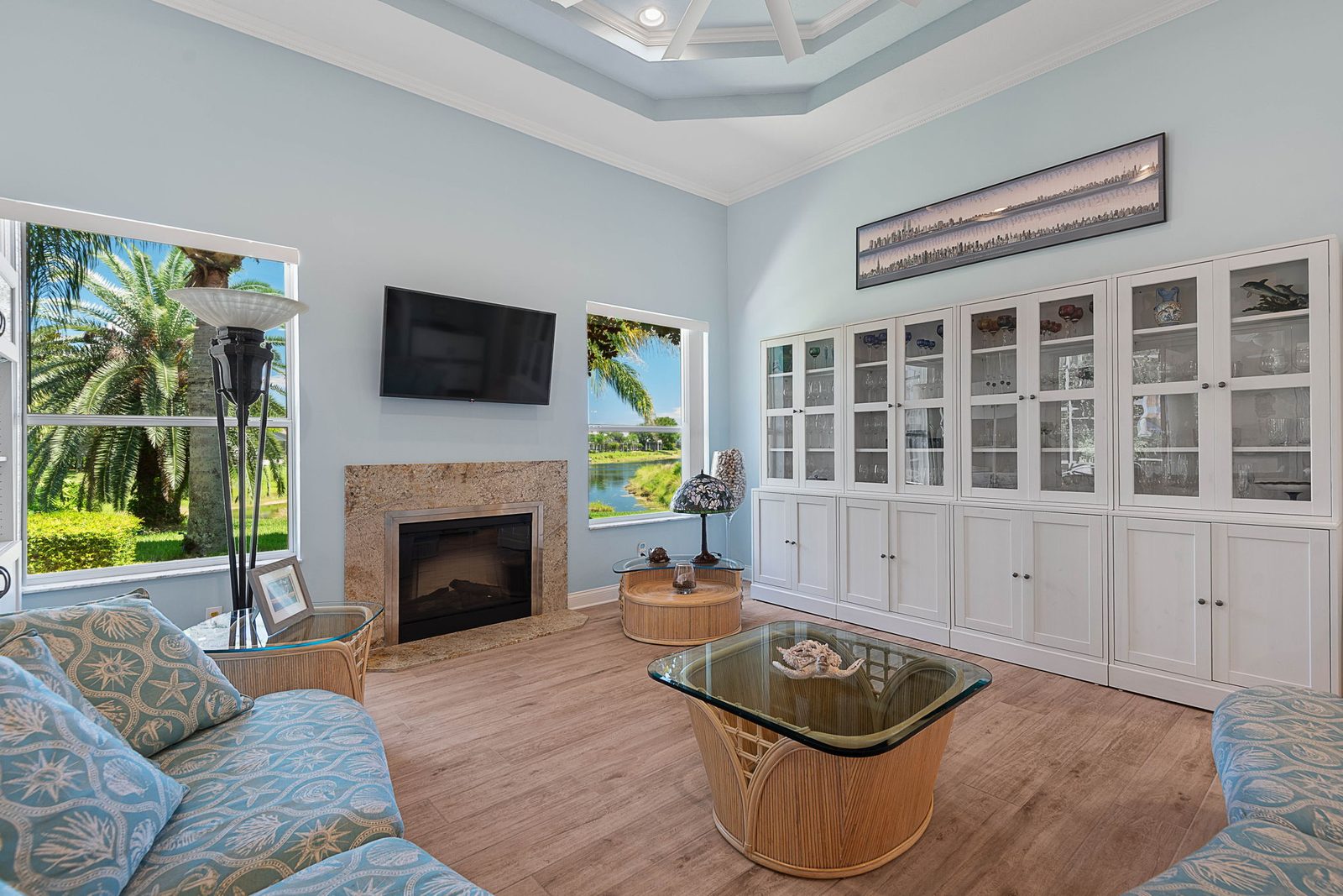 Family room with coffered ceiling, built-in cabinetry, gas fireplace, and long lake views
